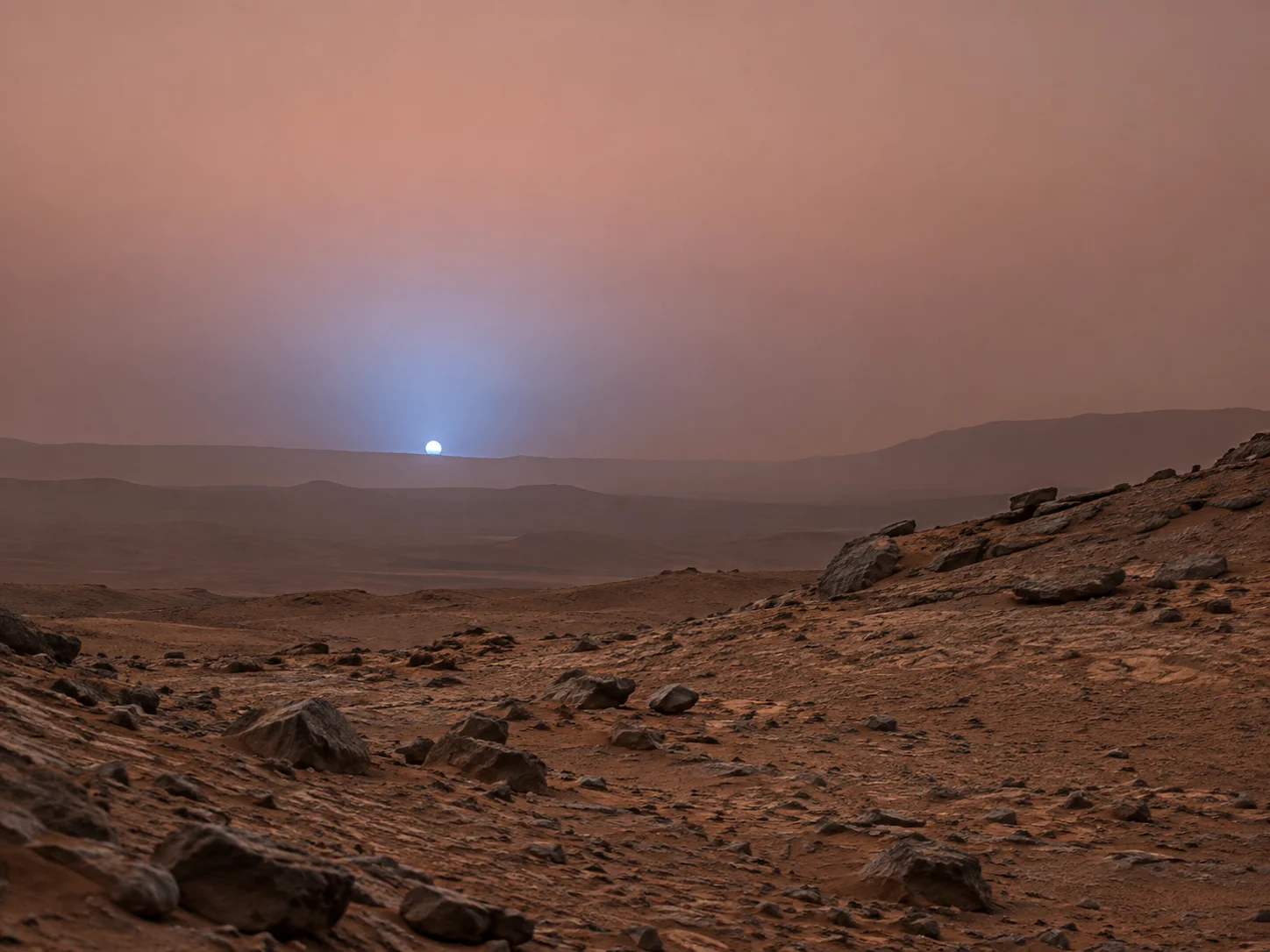 A small blue sunset above a calm rocky landscape on Mars
