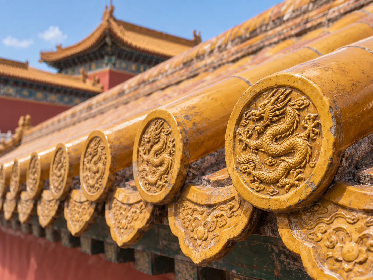 A row of yellow glazed roof tiles ending in round caps decorated with dragons